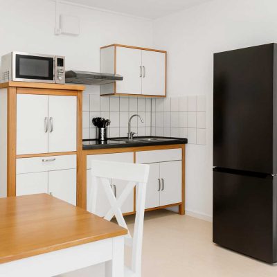 Helle Küche mit Esstisch, Kühlschrank, Mikrowelle und Spüle im Studentenwohnheim Hildebrandstraße Dresden