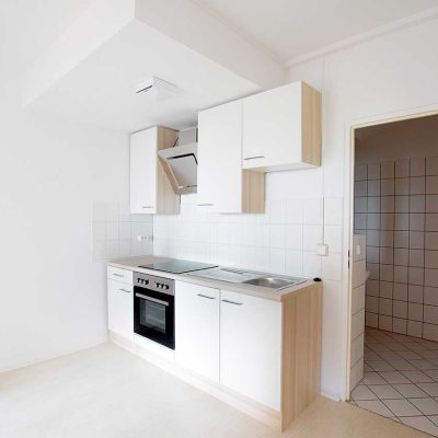 Neue helle Küchenzeile mit Herd und weißen Schränken im Studentenwohnheim Hildebrandstraße Dresden