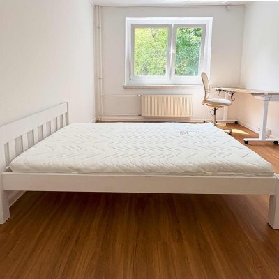 Helles Schlafzimmer mit Bett, Schreibtisch und Blick ins Grüne im Studentenwohnheim Hildebrandstraße Dresden