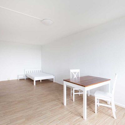 Moeblierter Raum mit Tisch und Stuehlen im Studentenwohnheim Hildebrandstrasse Dresden